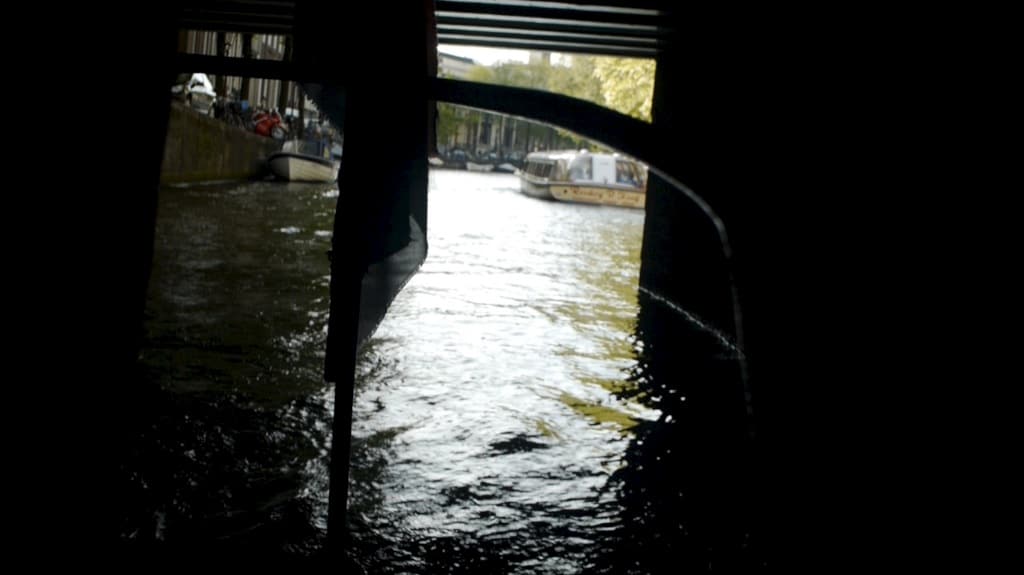 Boat driving under a bridge in Amsterdam